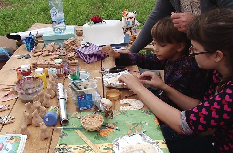 Kinderen maken tijdens een kunstworkshop kleurrijke tekeningen en kunstwerkjes onder begeleiding in Museum Vlaardingen